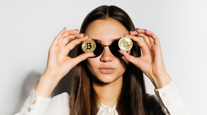 girl holding crypto currency in front of her eyes