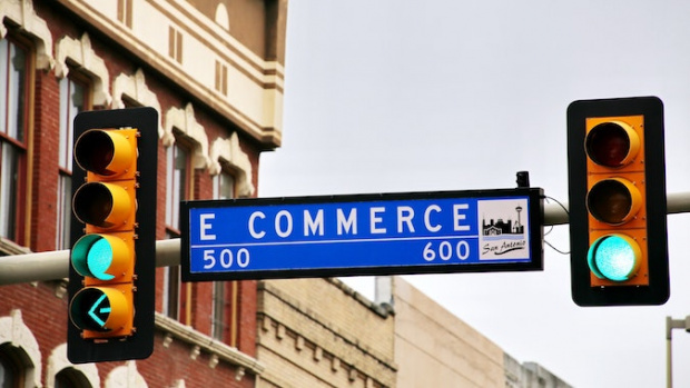  two traffic lights with green light and a sign written "e commerce" between them.