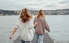 Two women walking down a pier